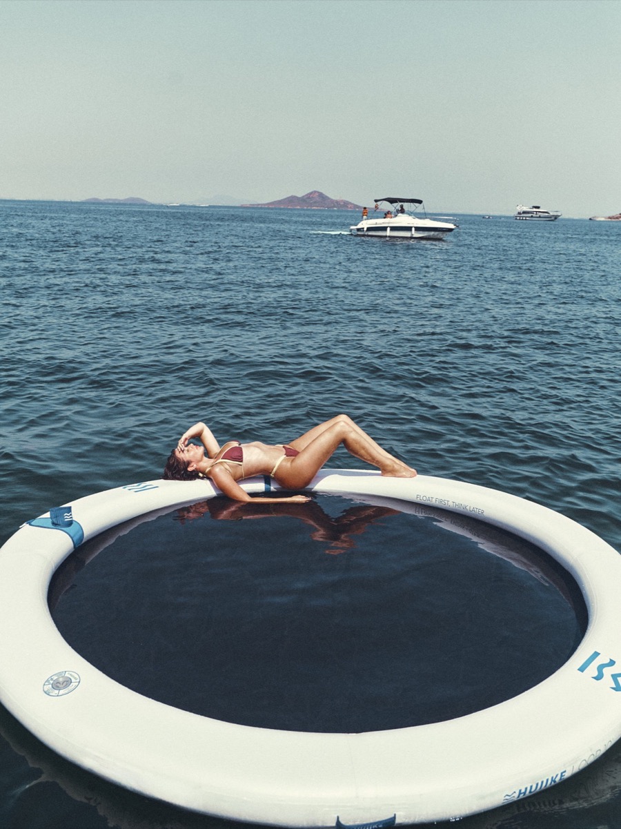 Persona relajándose sobre una plataforma flotante en el mar